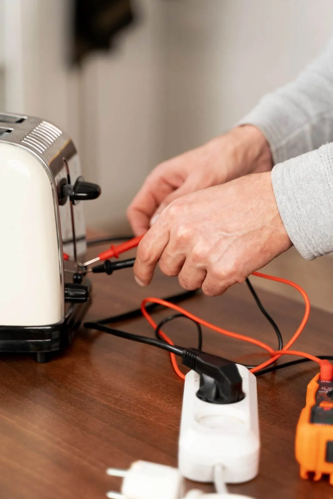 Technician checking a kitchen appliance with a meter