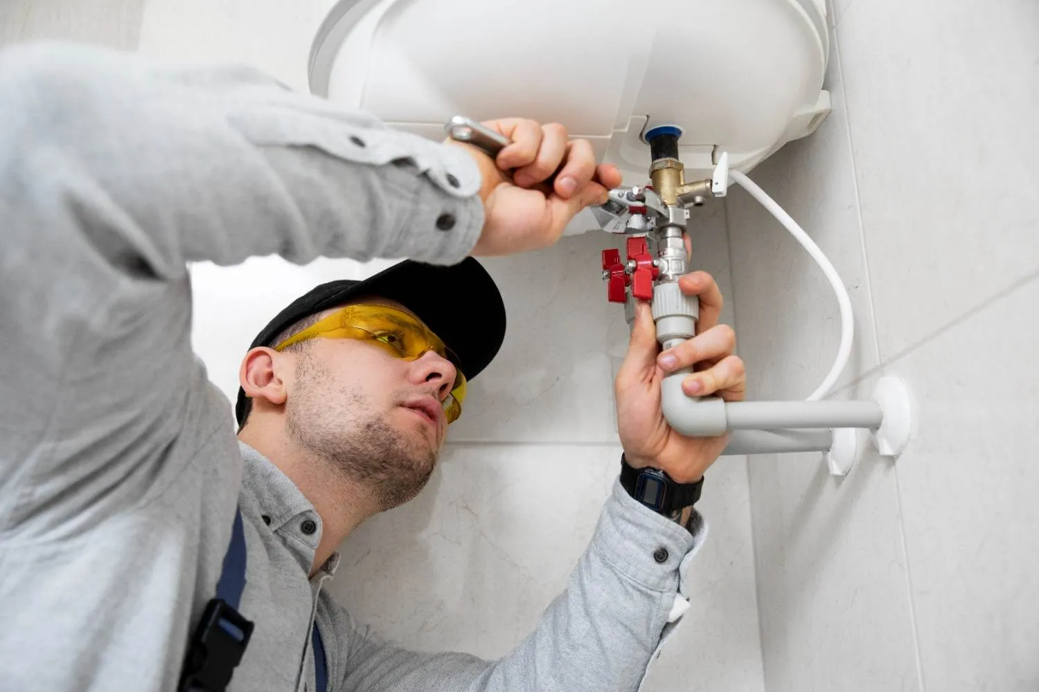 Technician fitting a valve on a water heater